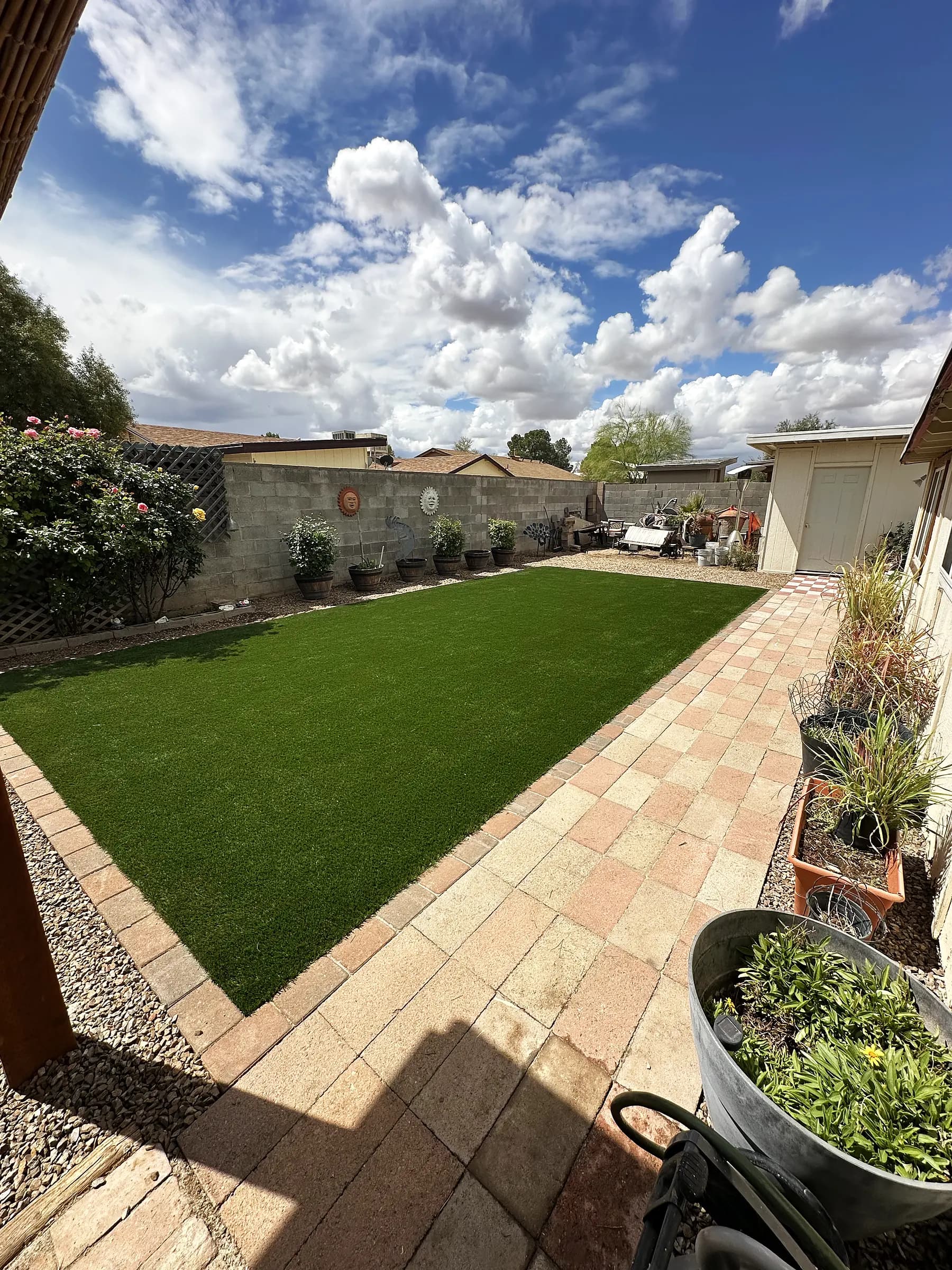 Rectangular artificial turf lawn framed by a paver border in a Tucson backyard